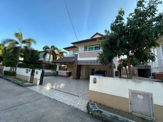 Spacious two-story house with a paved driveway and tropical landscaping