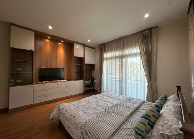 Spacious bedroom with modern furniture and large windows