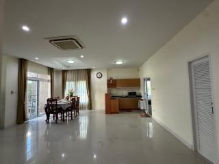 Spacious combined living and dining area with kitchen in the background