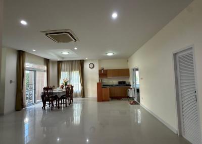 Spacious combined living and dining area with kitchen in the background
