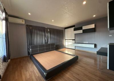 Modern bedroom with large bed and wooden flooring