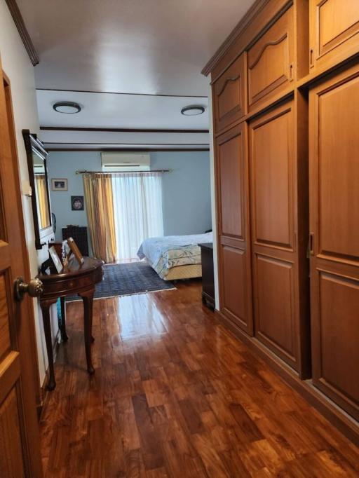 Cozy bedroom with wooden flooring, built-in wardrobes, and a work desk