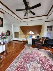 Home office with wooden floors, area rug, and ceiling fan