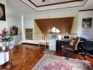 Home office with wooden floors, area rug, and ceiling fan