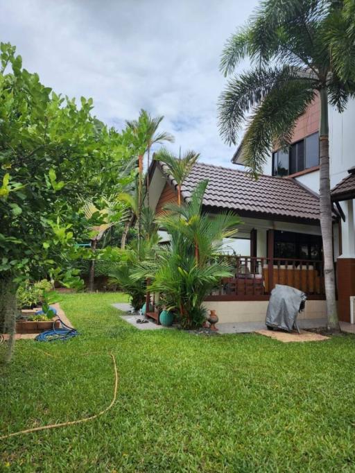 Cozy suburban home with a lush green lawn and tropical landscaping