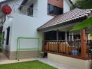 White and brown two-story house with balcony and outdoor patio