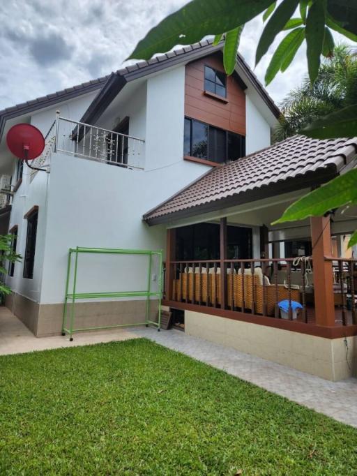 White and brown two-story house with balcony and outdoor patio