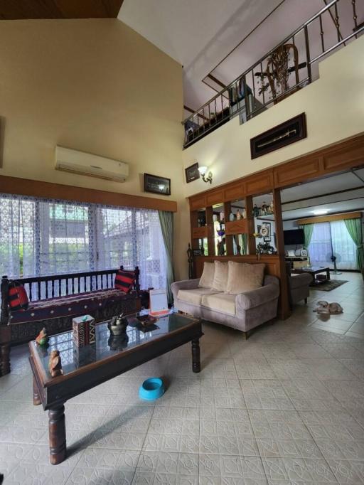 Spacious living room with high ceiling and natural lighting