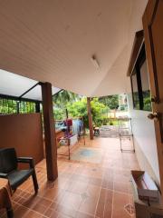 Covered patio area with tiled flooring and garden view
