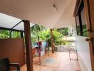 Covered patio area with tiled flooring and garden view