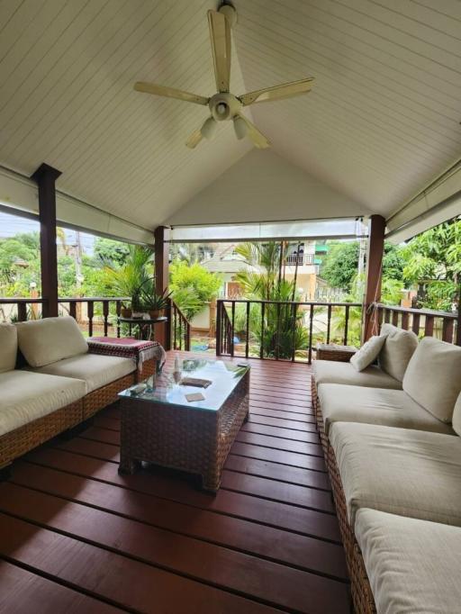 Spacious covered patio with comfortable seating and tropical views