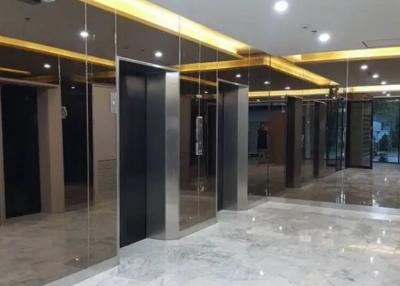 Modern building lobby with reflective marble floors and multiple elevator entrances