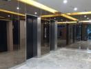 Modern building lobby with reflective marble floors and multiple elevator entrances