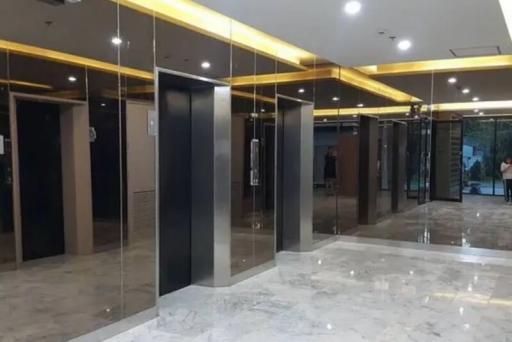 Modern building lobby with reflective marble floors and multiple elevator entrances