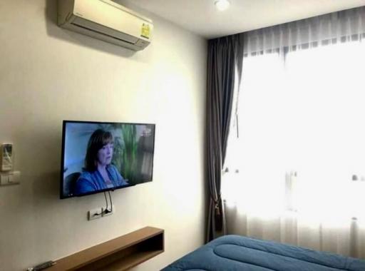 Modern bedroom with wall-mounted television and air conditioning