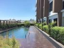 Outdoor swimming pool alongside residential building with sunny blue sky