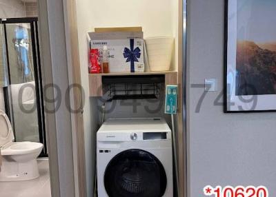 Compact laundry area with washing machine and shelving units inside a residential property