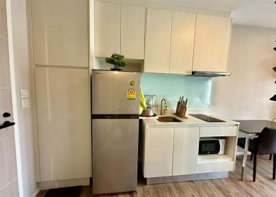 Modern compact kitchen with white cabinetry and stainless steel appliances