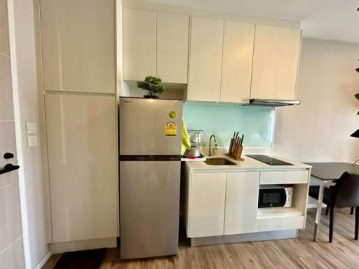 Modern compact kitchen with white cabinetry and stainless steel appliances