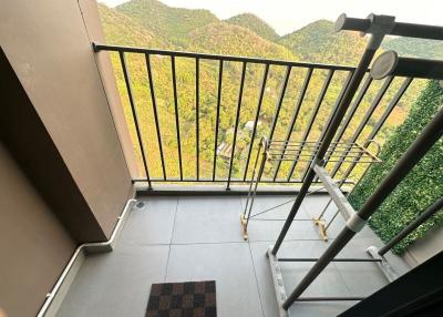 A balcony with scenic mountain views and drying rack