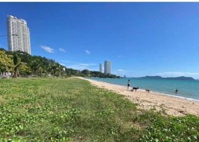 Beachfront with nearby high-rise buildings and people enjoying the shore