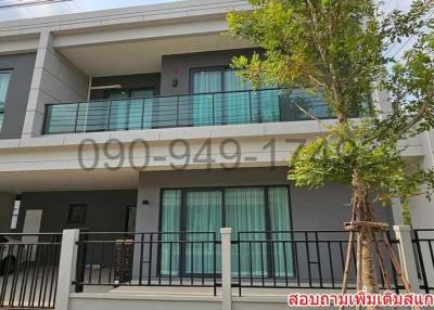 Modern two-story residential house with balcony and carport