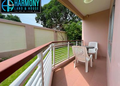 Spacious balcony with outdoor seating and a railing overlooking a private yard