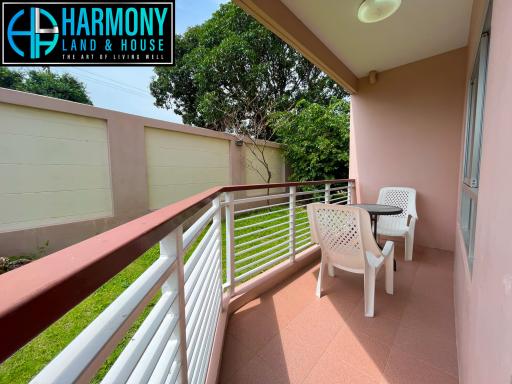 Spacious balcony with outdoor seating and a railing overlooking a private yard