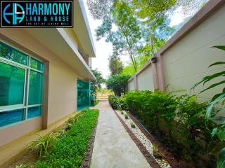 Pathway leading to a house with pool and lush greenery