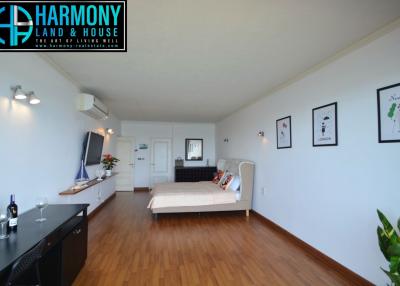 Spacious bedroom with hardwood floors, comfortable bedding, and modern decor