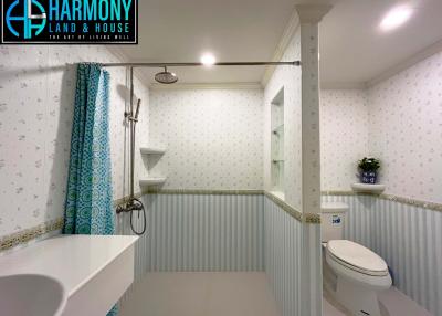 Modern bathroom with blue and white wallpaper, clean white fixtures, and elegant design