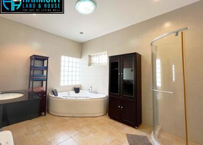 Spacious bathroom with modern fixtures, including a large tub and glass shower enclosure