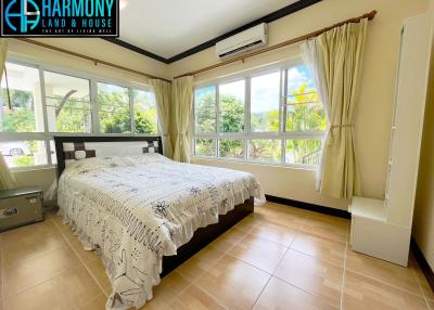Bright and spacious bedroom with large windows and tropical view