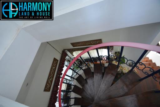 Spiral staircase inside a home with Harmony Land and House branding