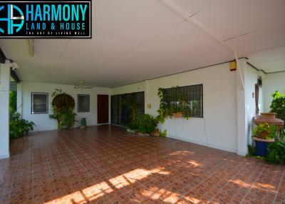 Spacious covered patio area with tile flooring and hanging plants