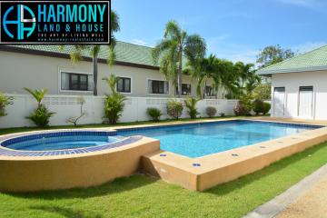Spacious backyard with a swimming pool and attached whirlpool next to a residential building