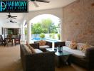 Spacious and well-furnished covered patio with comfortable seating and a tropical view