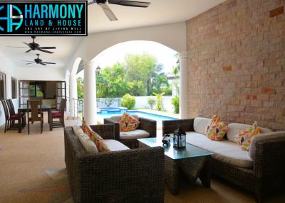 Spacious and well-furnished covered patio with comfortable seating and a tropical view