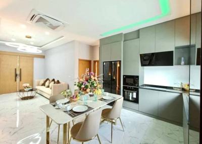 Modern kitchen with integrated appliances and dining area with stylish table and chairs