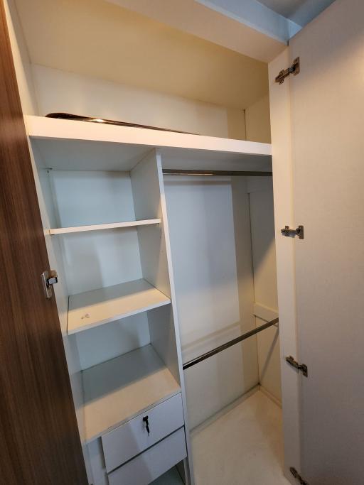 Open built-in storage closet with shelves and drawers in a home