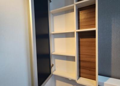 Compact storage area with built-in shelving and a small bench seat
