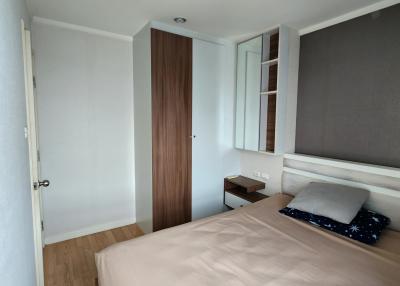 Compact bedroom with a single bed, built-in wardrobe, and wooden flooring