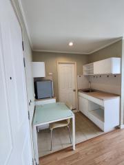 Compact kitchen with wooden floor and white cabinetry