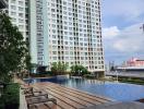 High-rise residential building with outdoor swimming pool and lounge area