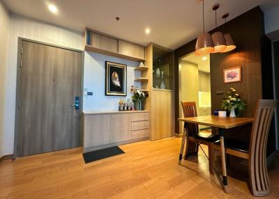 Modern apartment interior with a well-lit dining area and wooden finishes