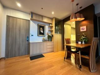 Modern apartment interior with a well-lit dining area and wooden finishes