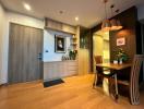 Modern apartment interior with a well-lit dining area and wooden finishes