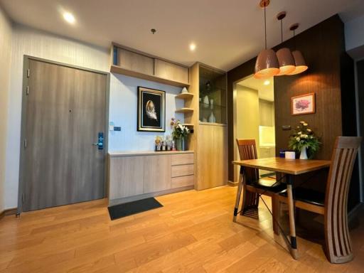 Modern apartment interior with a well-lit dining area and wooden finishes