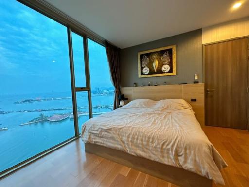 Spacious bedroom with a large window offering a scenic ocean view