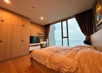 Cozy bedroom with ocean view, wooden flooring, and modern furniture